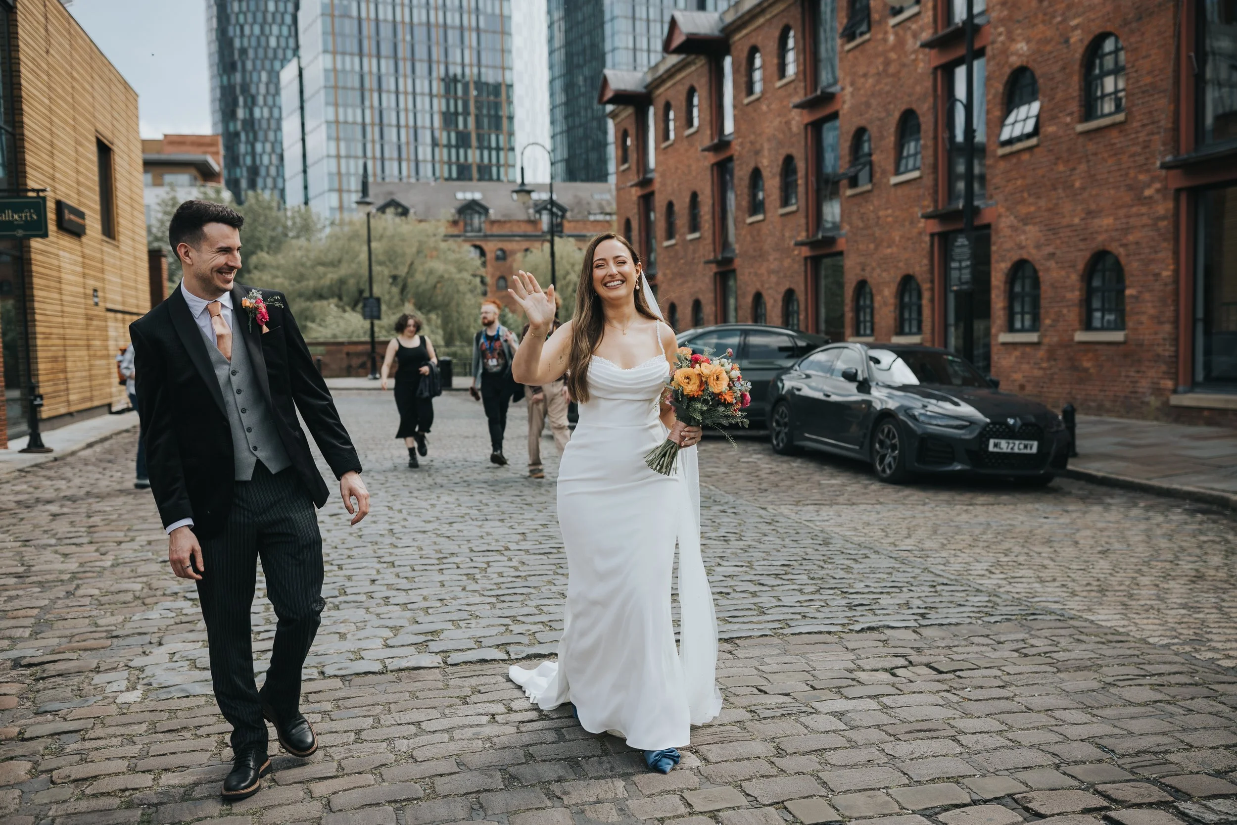 Bride and Groom walking and laughing in Castlefield Manchester. 