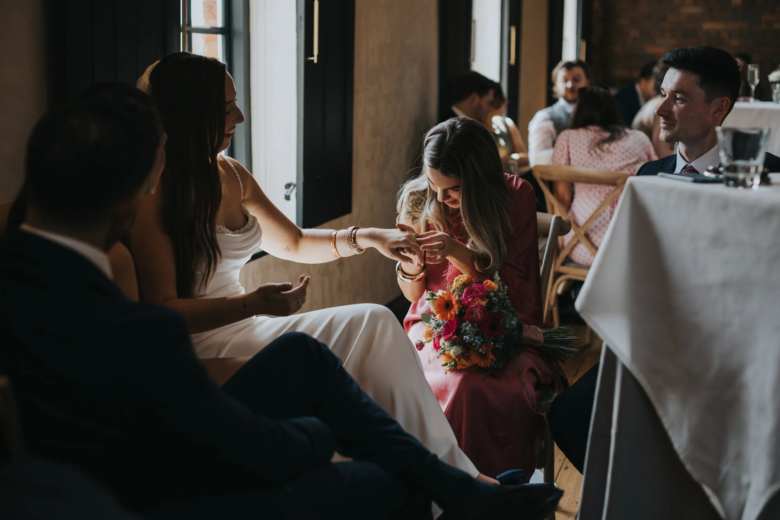 Wedding guest looks at brides ring. 