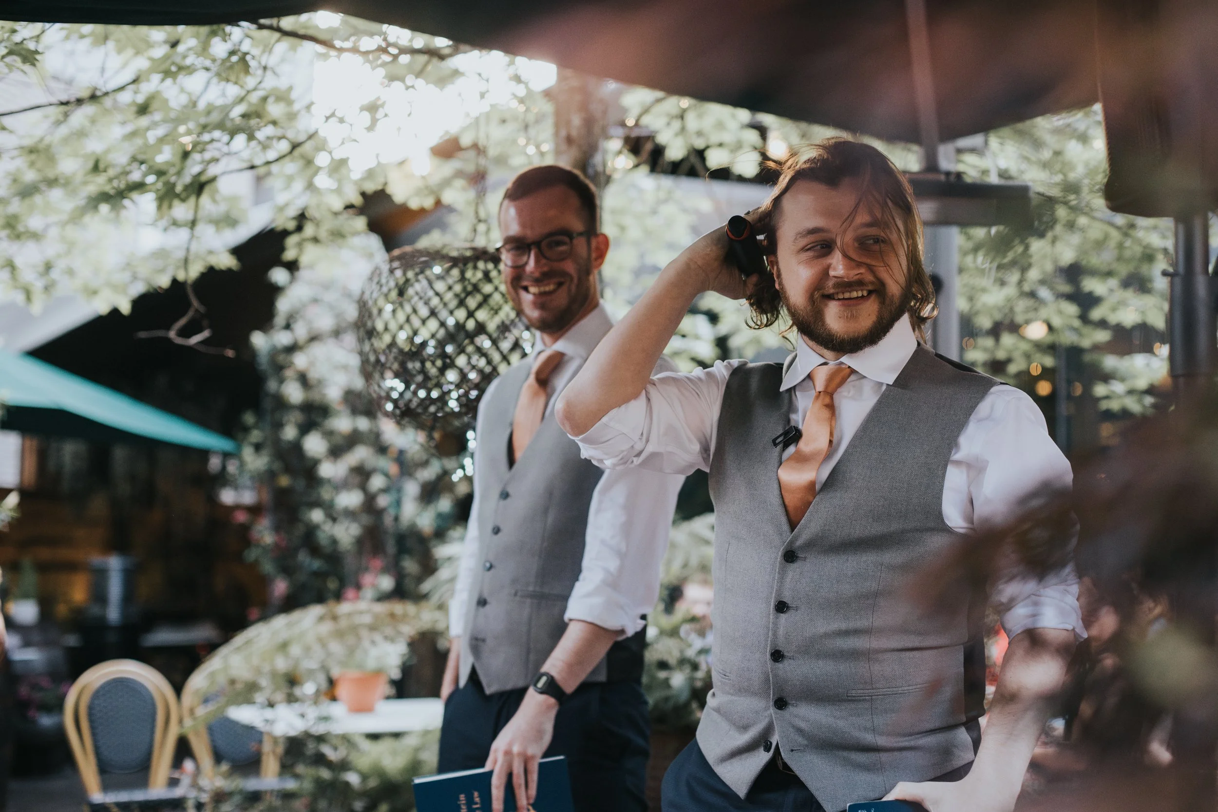 Best men laugh as they give their speech. 