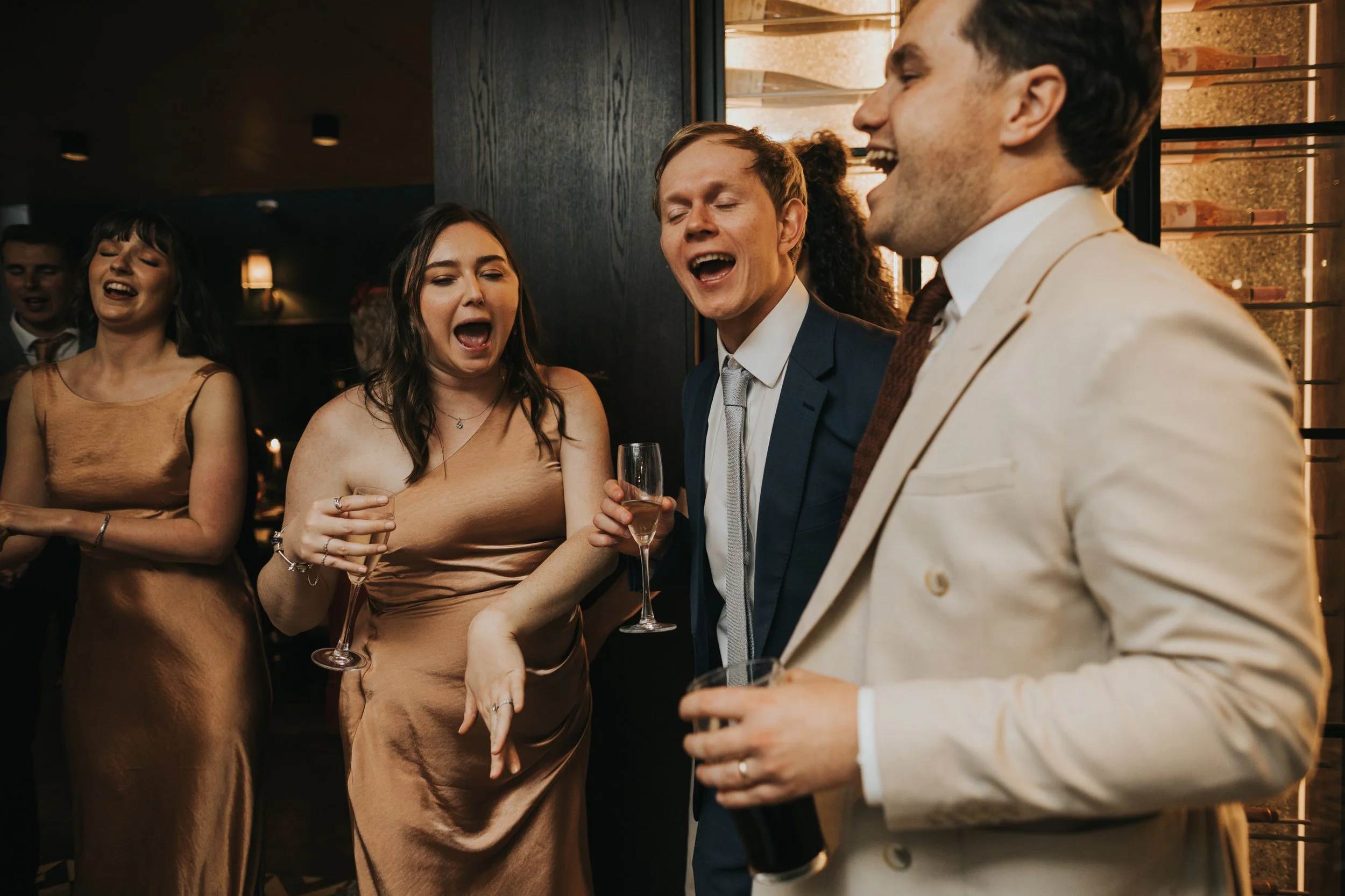 Wedding guests laughing and signing on dance floor. 