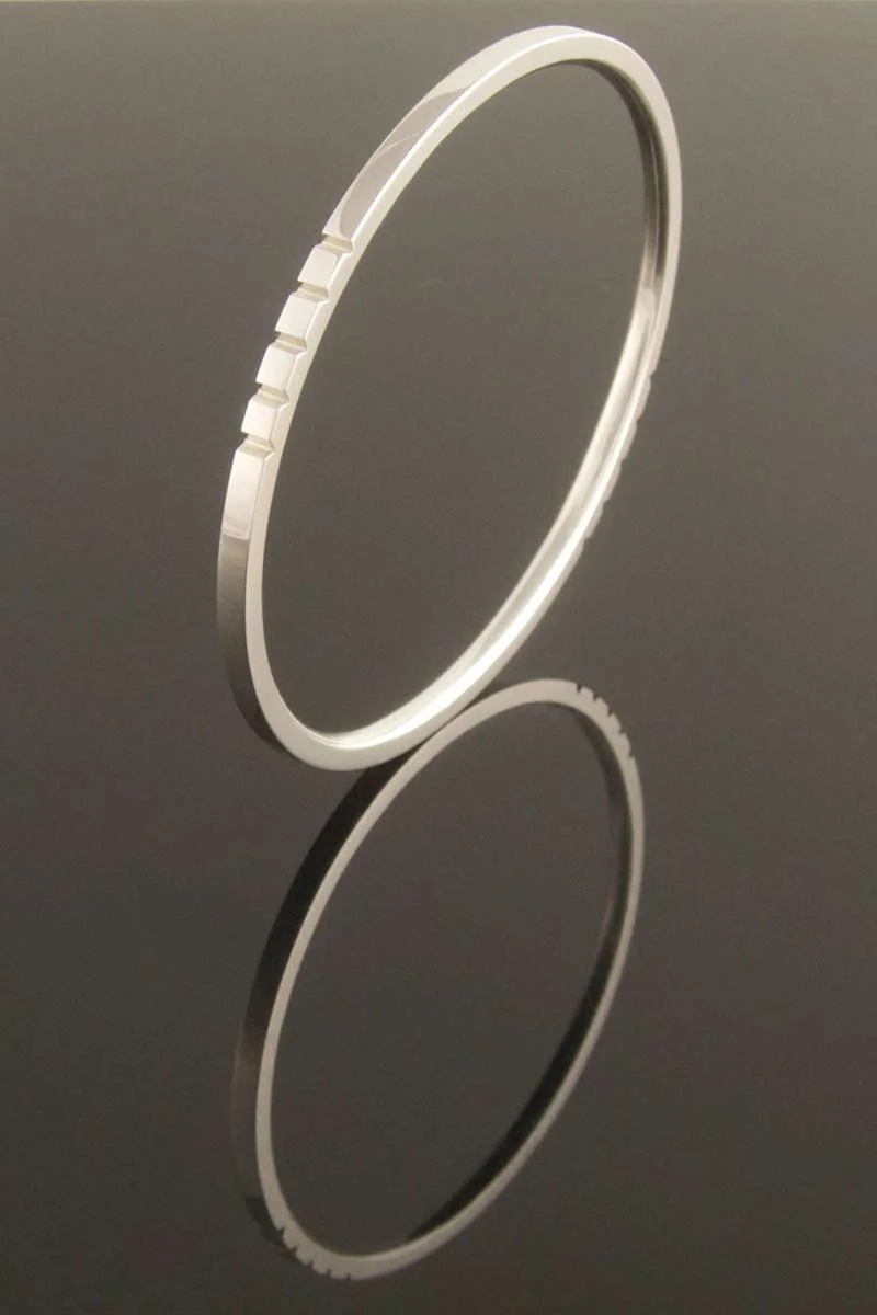 Oval silver bangle with grooves