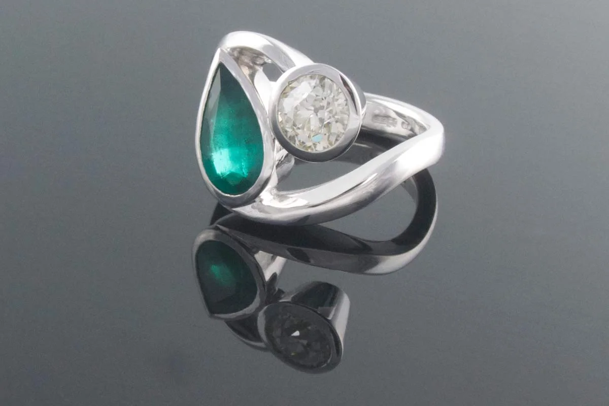 Emerald and diamond twist engagement ring