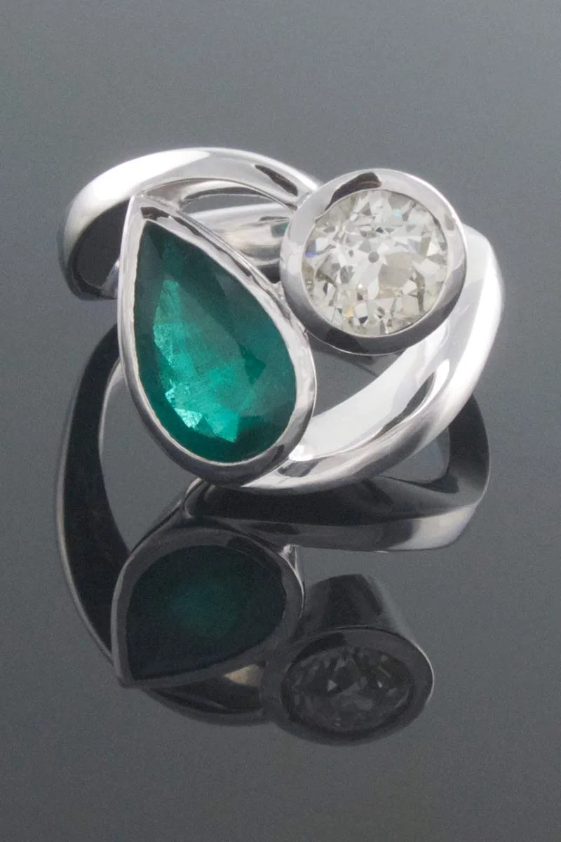 Emerald and diamond twist engagement ring