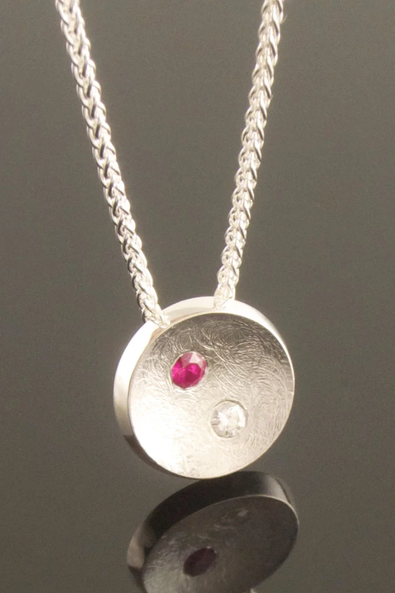 Silver pendant with gypsy set ruby and diamond