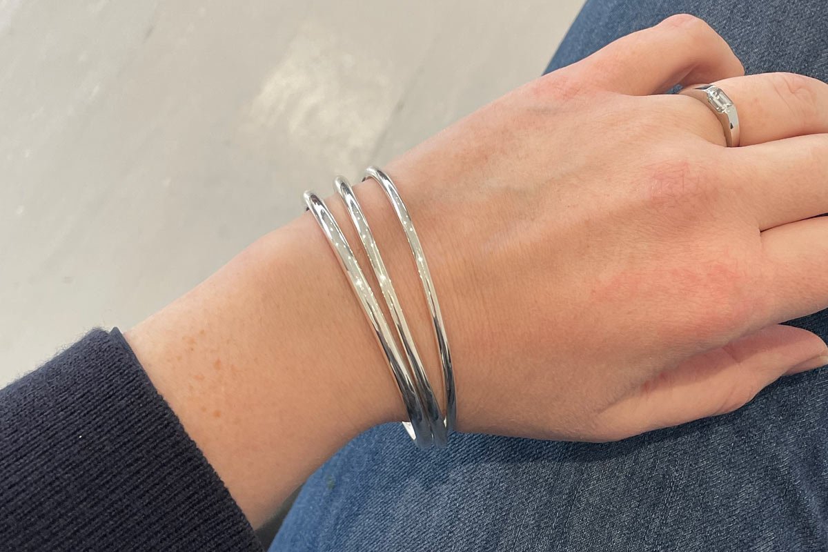 Handmade 4mm, 3.5mm and 3mm round wire oval sterling silver bangles on wrist