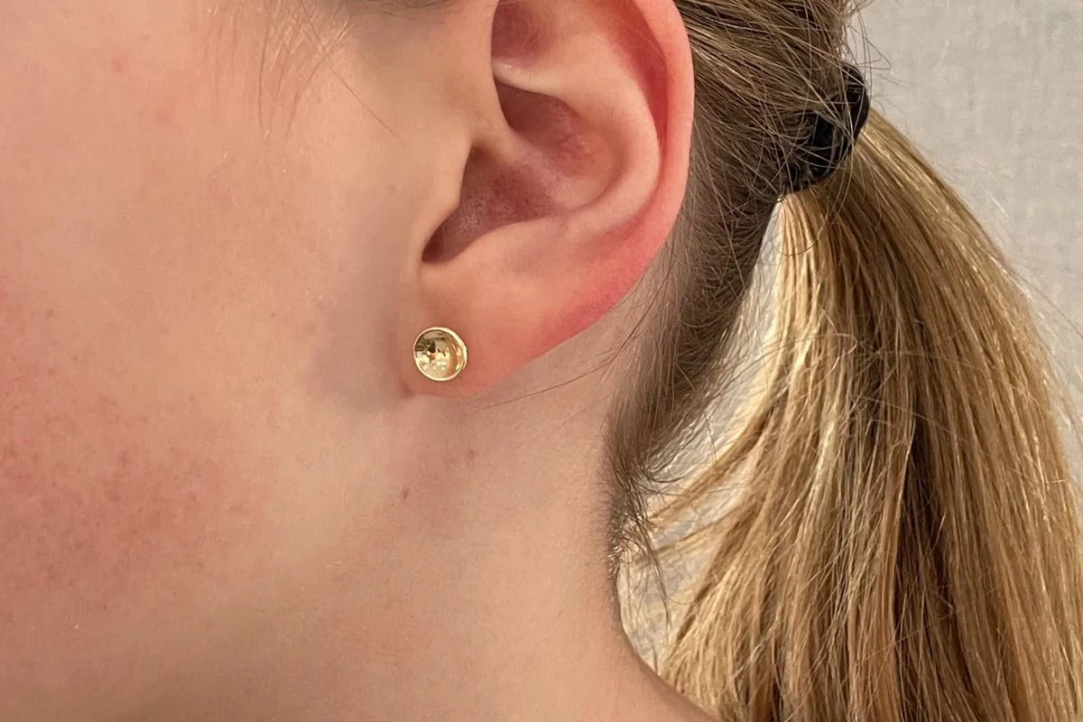 Concave 9ct yellow gold disc earring in wear