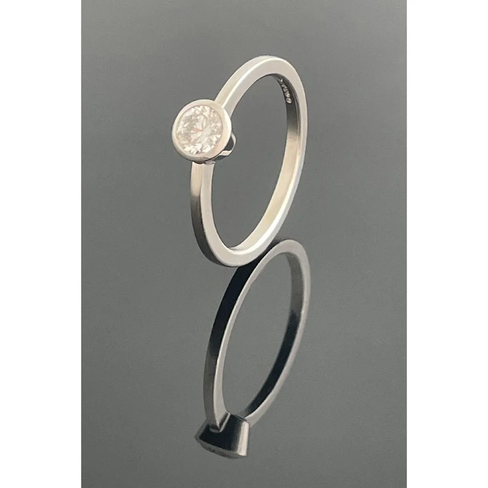 0.47ct round brilliant cut diamond engagent ring with contemporary bezel setting on a fine platinum band