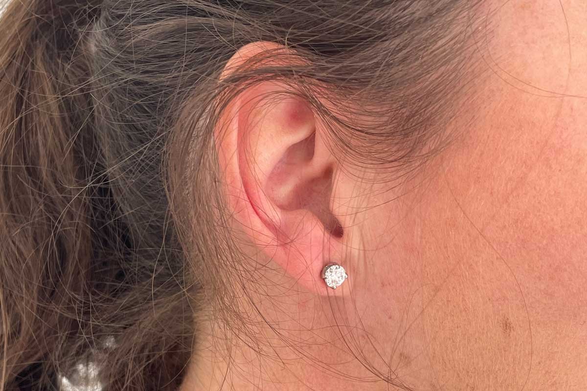 Claw set 6mm round brilliant cut diamond earring on model