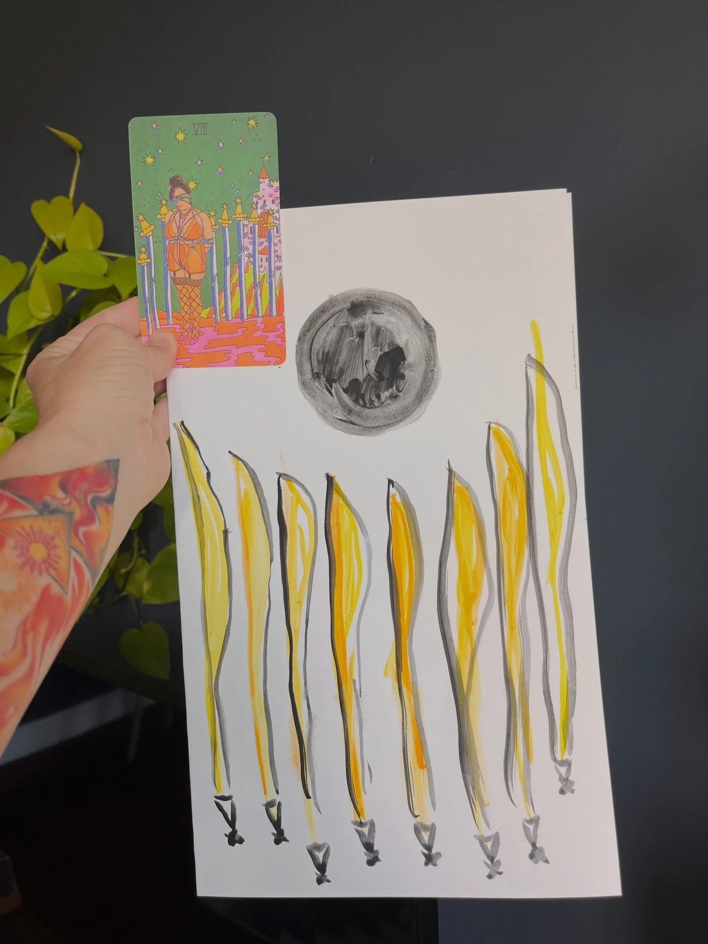 Image ID: My hand with a fantastic fire tattoo by @micahriot, holding a Tarot card by @ashandchess, and my original art with 8 swords and the new moon. 
End Image ID. 

Today, I would like to share with you three upcoming offerings. Here they are!

A