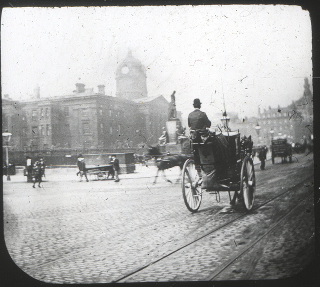 The original Lewis’s in the background with ‘spire’. Manchester infirmary in the foreground (now Piccadilly Gardens) Circa 1890s.