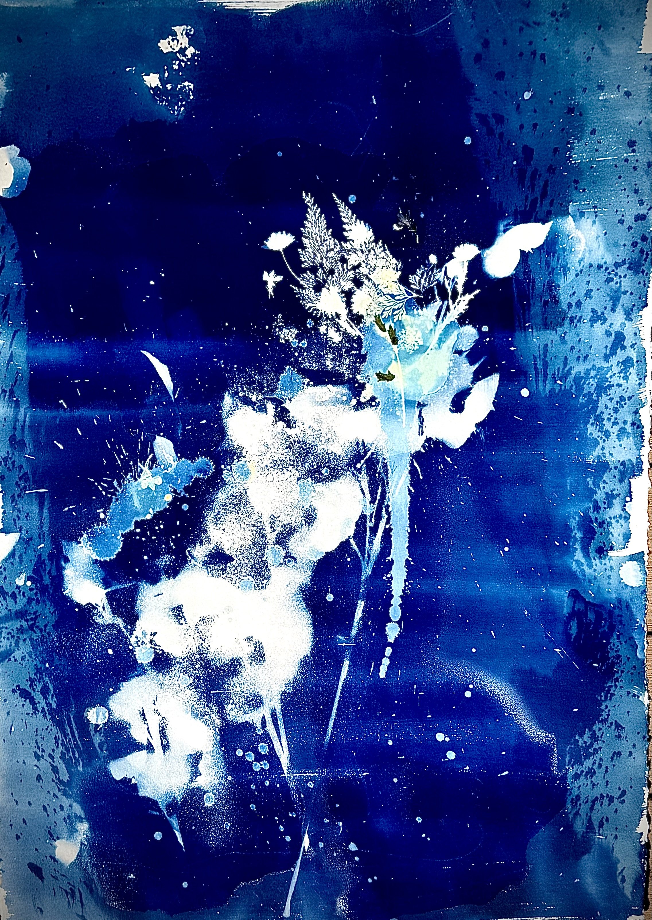 Abstract dark blue background with white splatters, paint drips, and a cluster of white and light blue floral or botanical silhouettes in the center.