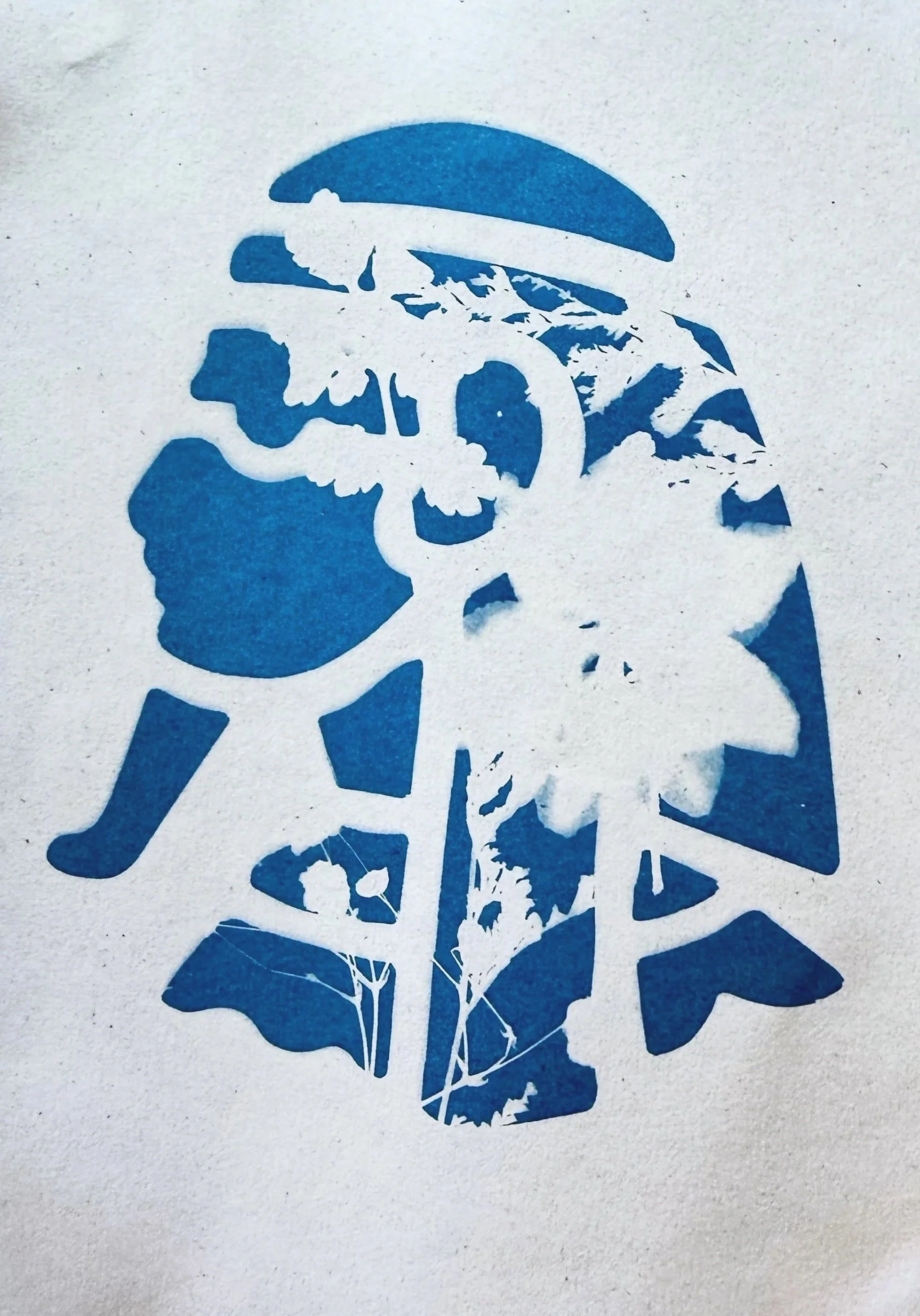 Stencil art of a person in profile with a mohawk hairstyle, lips, nose, and eye visible, created using a layered paper-cut style with various shades of blue.