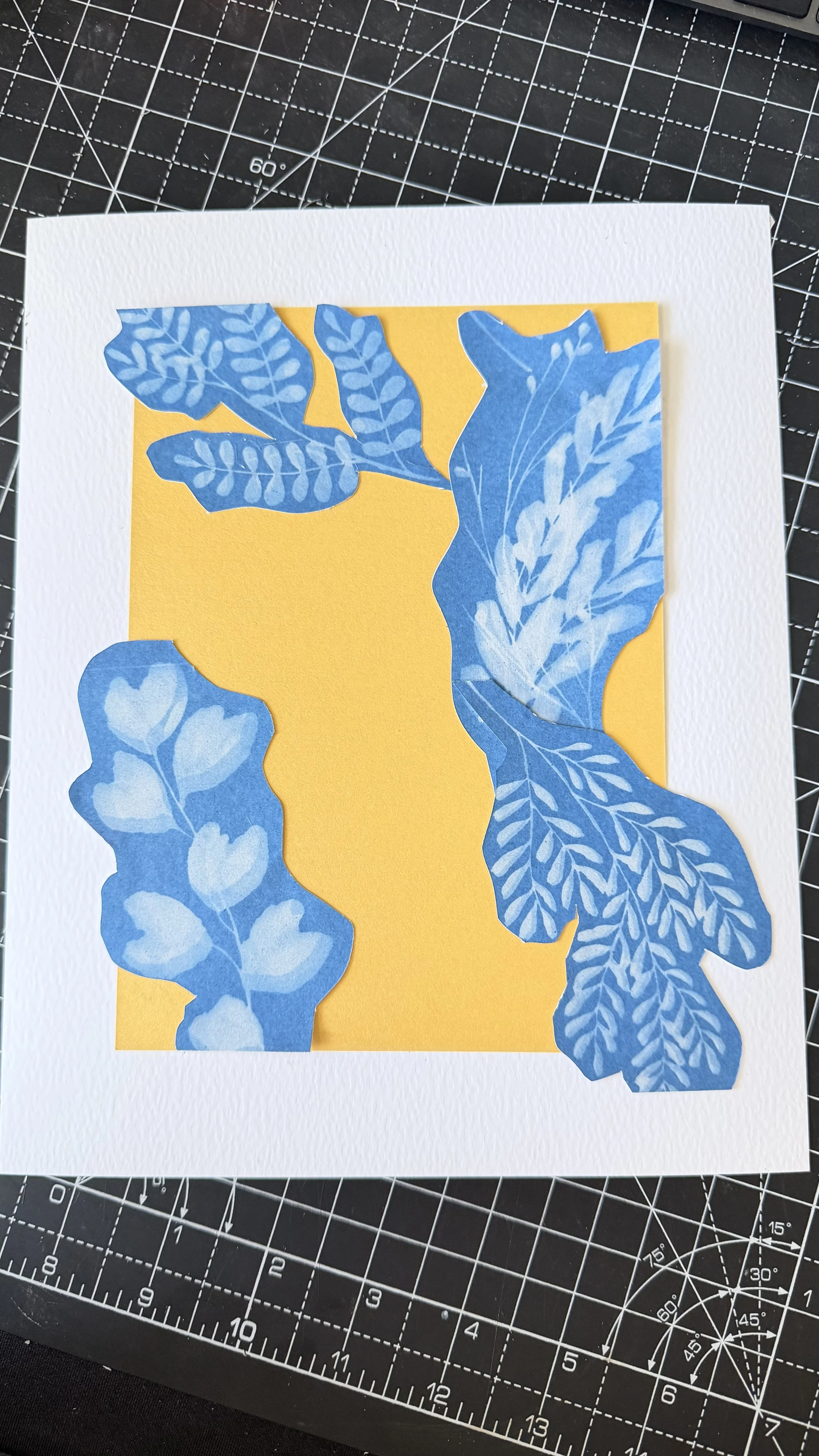 Blue botanical cutouts on yellow background in paper art project.