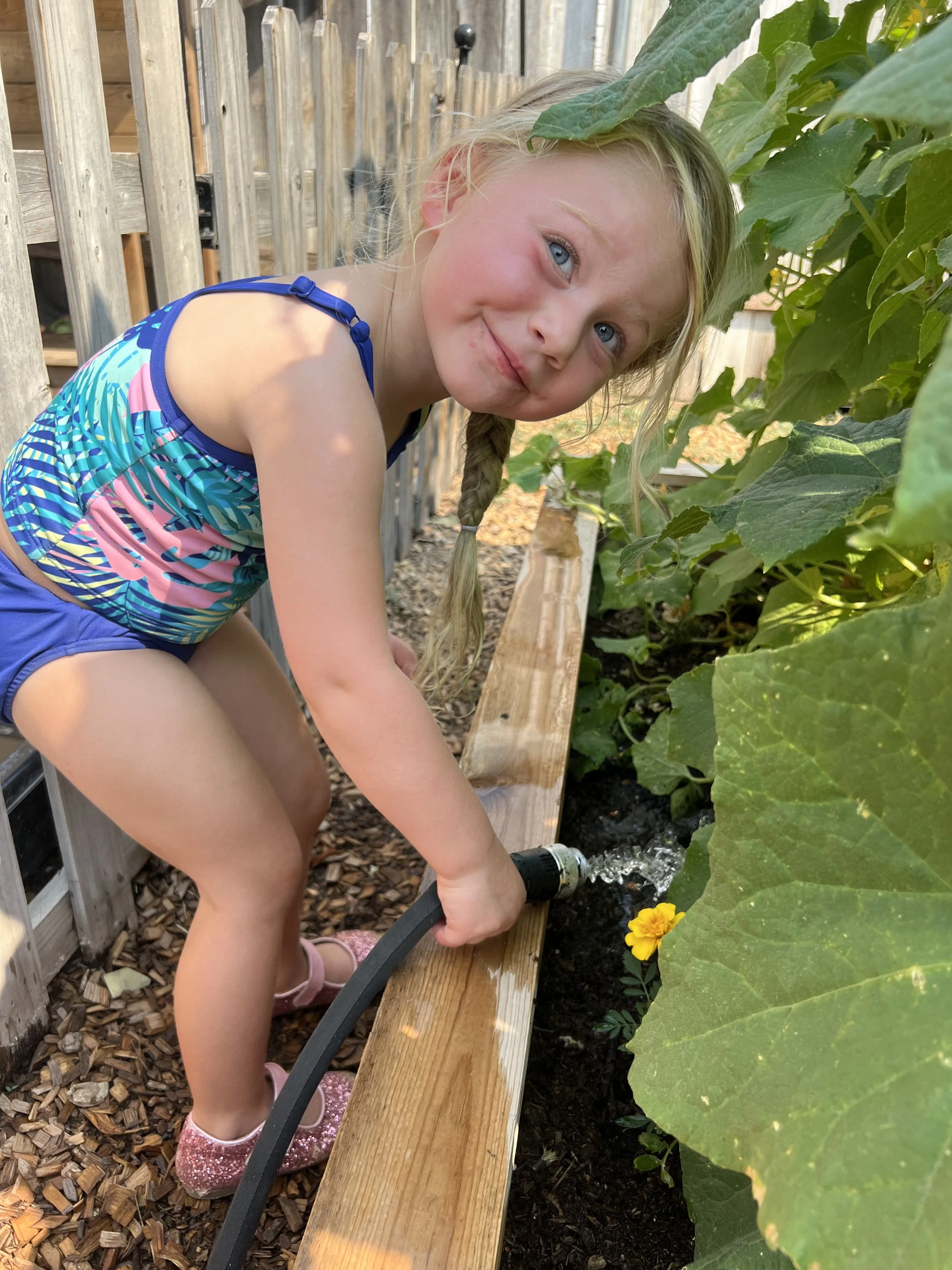 Student waters garden at school, a great way to learn