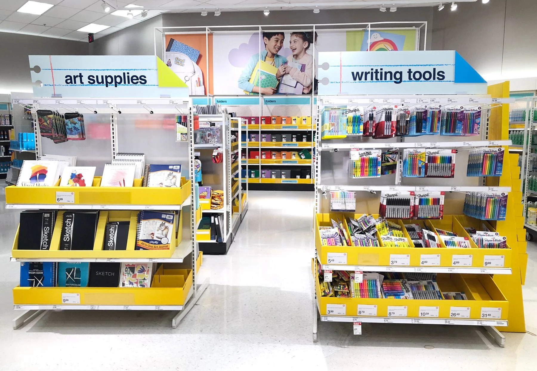 Two product shelves, topped with paper signs designed to look like notebook paper