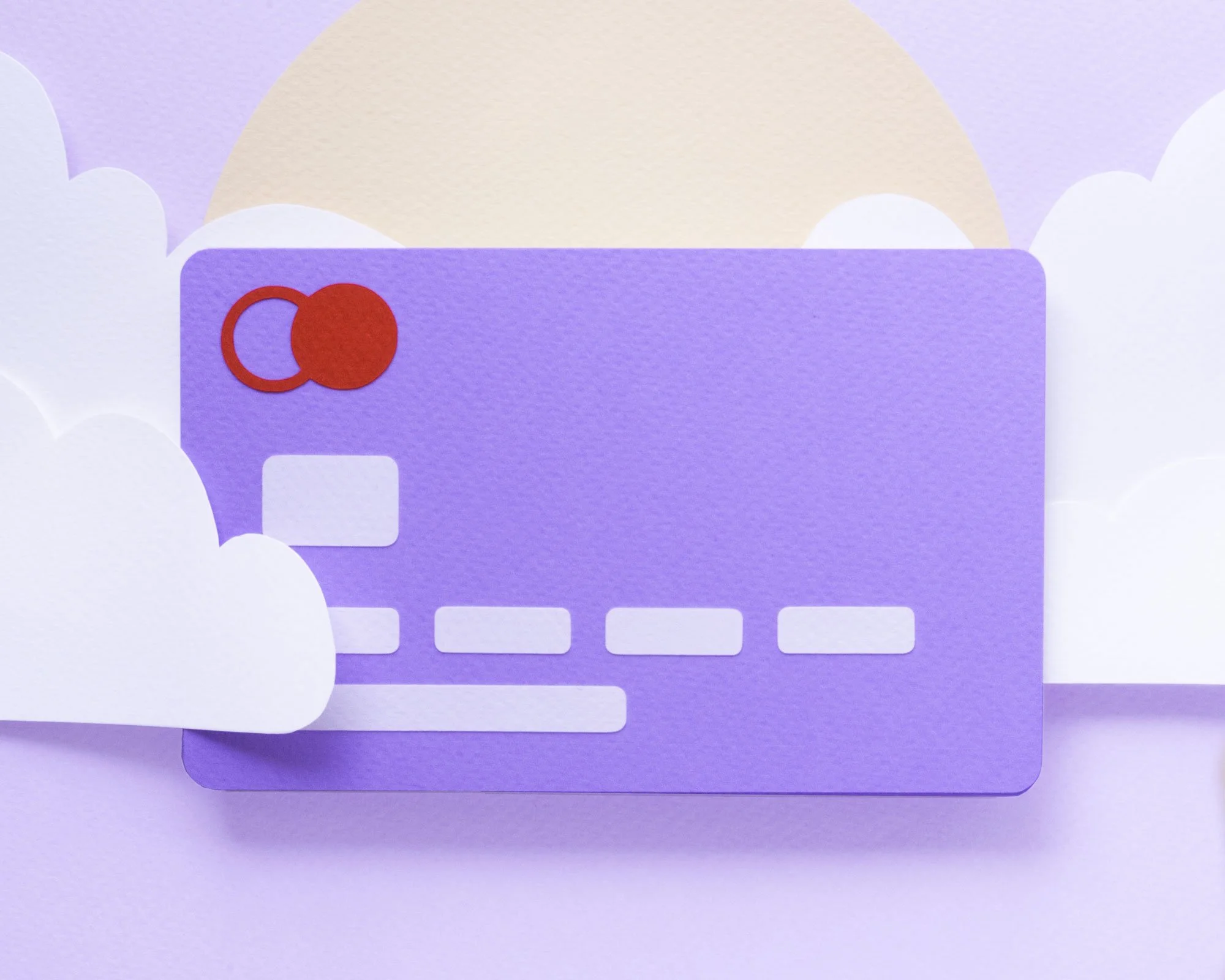 Paper scene with purple credit card among white paper clouds
