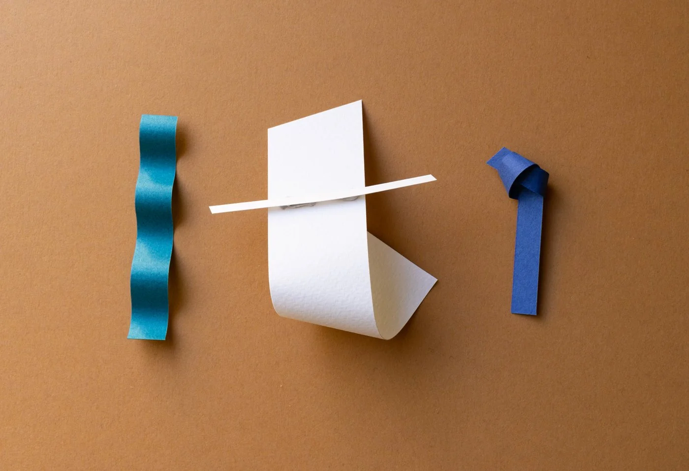 Pieces of paper represent letters "i" "t" and "i"