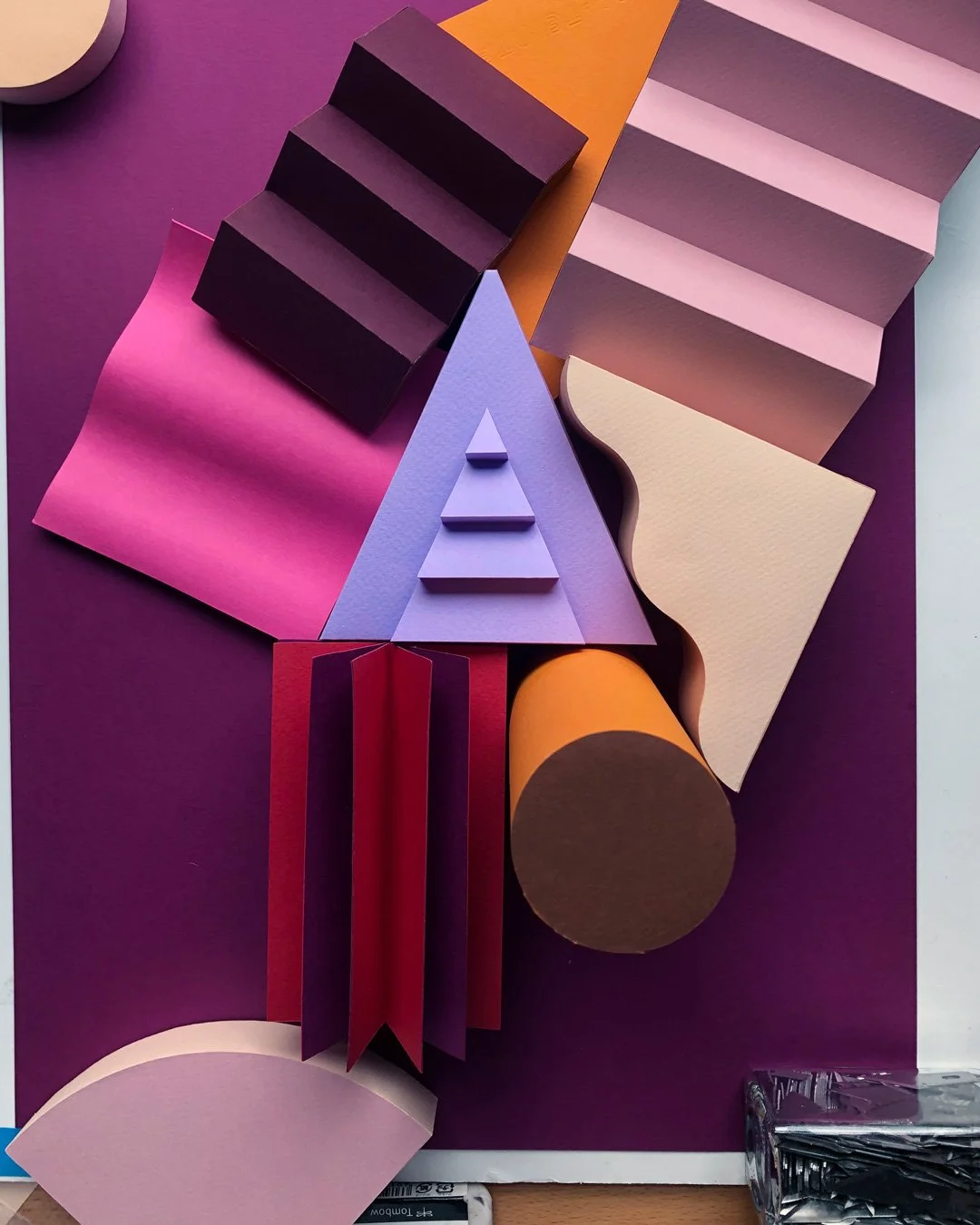 Photograph of paper shapes surrounding a paper triangle