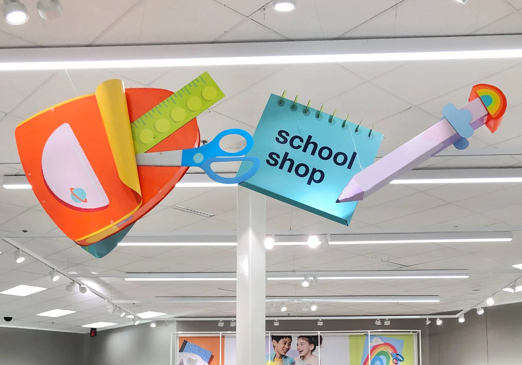 Photo of a paper backpack, notebook, and pencil suspended from the ceiling of a Target store