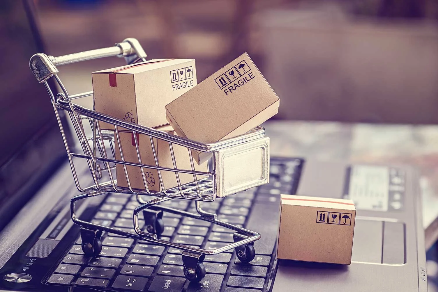 Boxen-in-einem-Trolley-auf-einer-Laptop-Tastatur-zur-Symbolisierung-fuer-Online-Shopping. .jpg