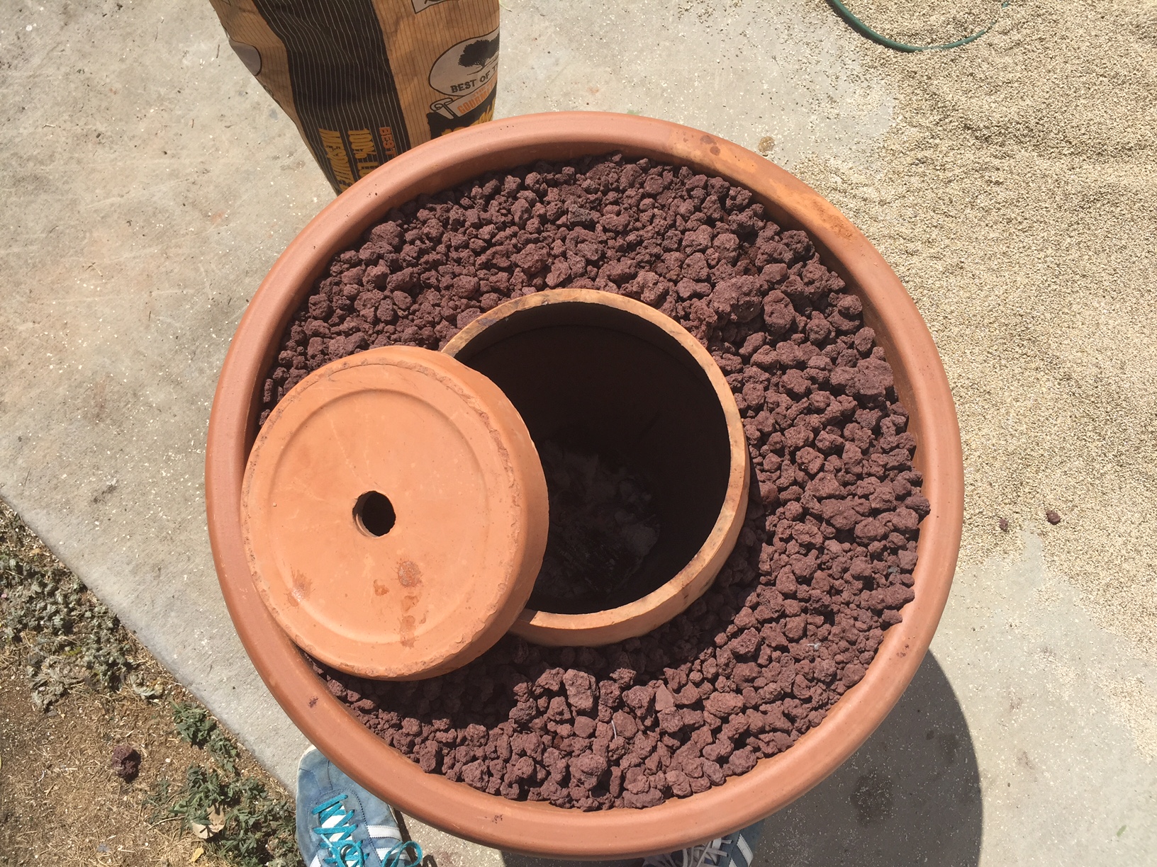  Using a masonry disk or tile cutting bit&nbsp;on a dremel (or an angle&nbsp;grinder), cut the bottom off your middle sized pot. This will be the lid, as shown here. Again, as with the holes in the bottom, make sure you drip water on the pot as you c