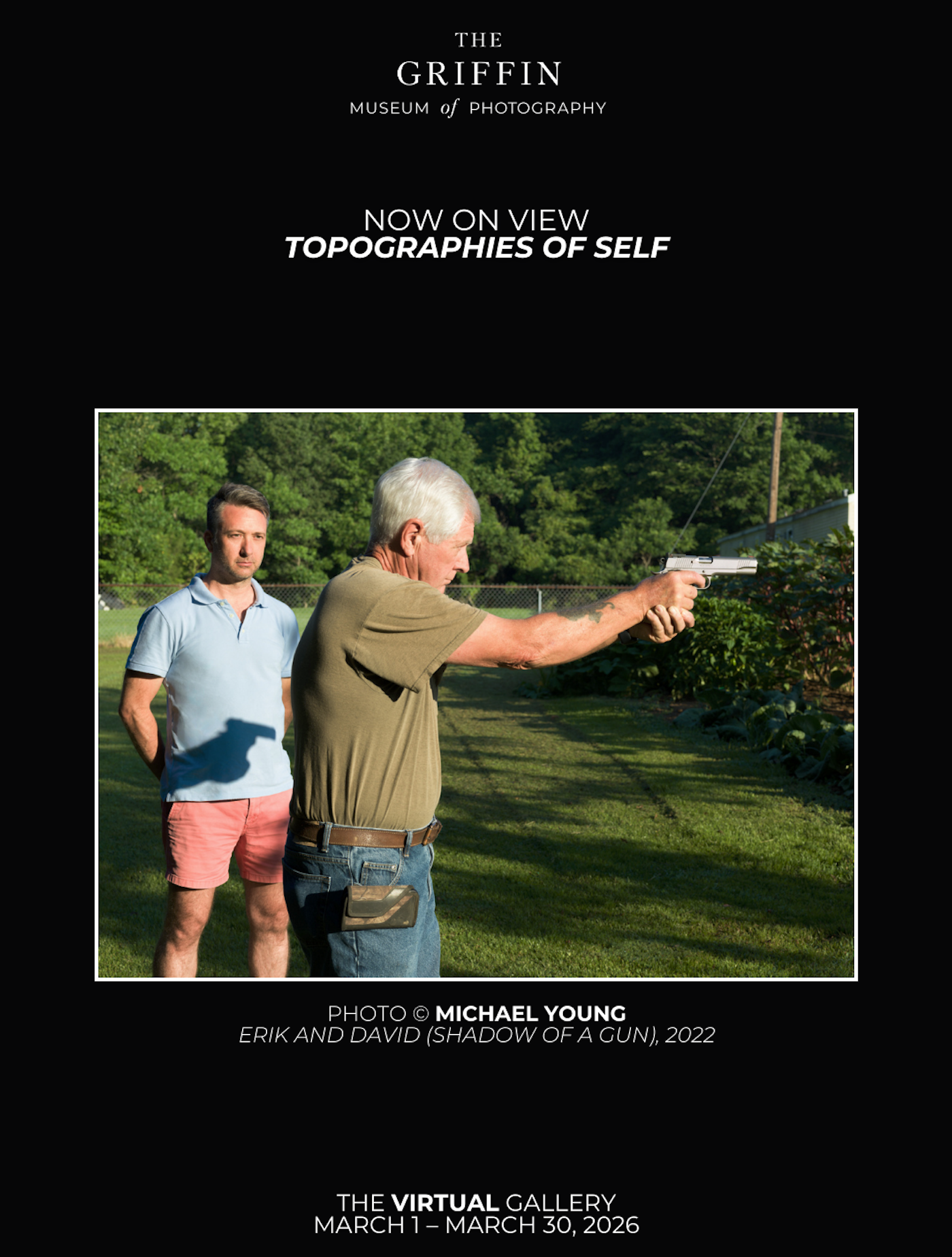 A shadow of a father shooting a gun is cast on his son who is watching him.