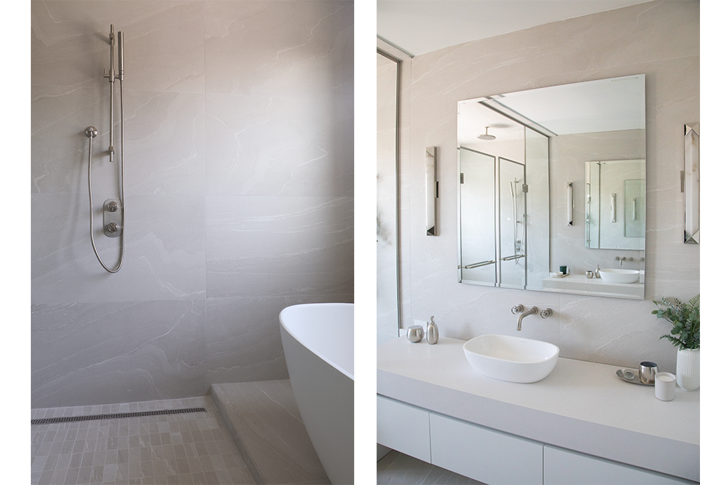 Modern bathroom with a rain shower, freestanding bathtub, large mirror, and sleek vanity sink.