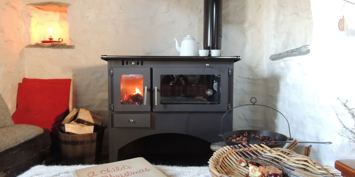 Fireplace with Welsh country antiques set against the lime-washed walls.