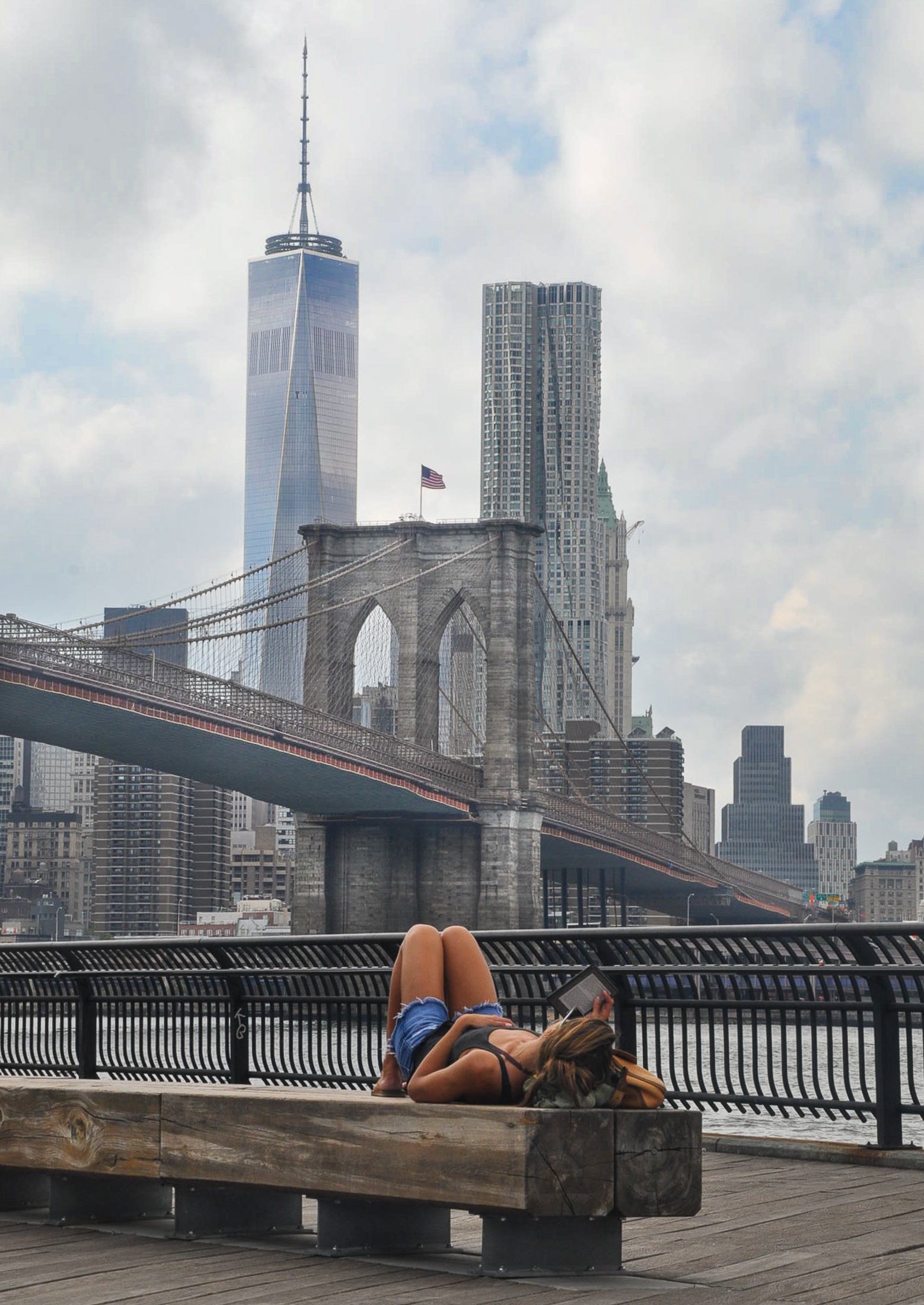   Relaxing with an e-book at Brooklyn Bridge Park and the Lower Manhattan skyline as backdrop. &nbsp;       (Photo © Joseph Kellard/kellardmedia.com)  