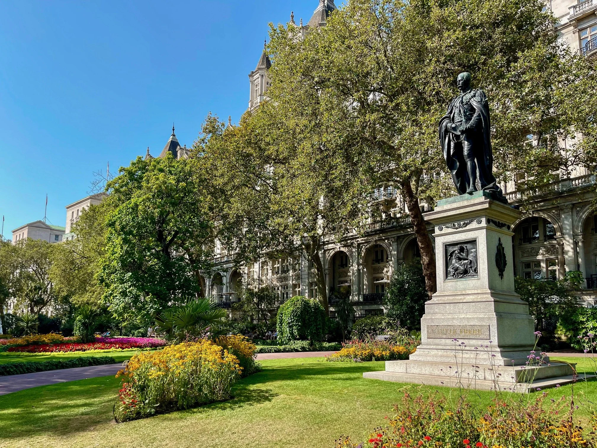  A statue of Sir Henry Bartle Frere (1815-1884) stands in Whitehall Gardens, a formal Victorian garden created in 1875 by George John Vulliamy alongside the River Thames Embankment. This bronze monument by Thomas Brock, unveiled in 1888, depicts the 