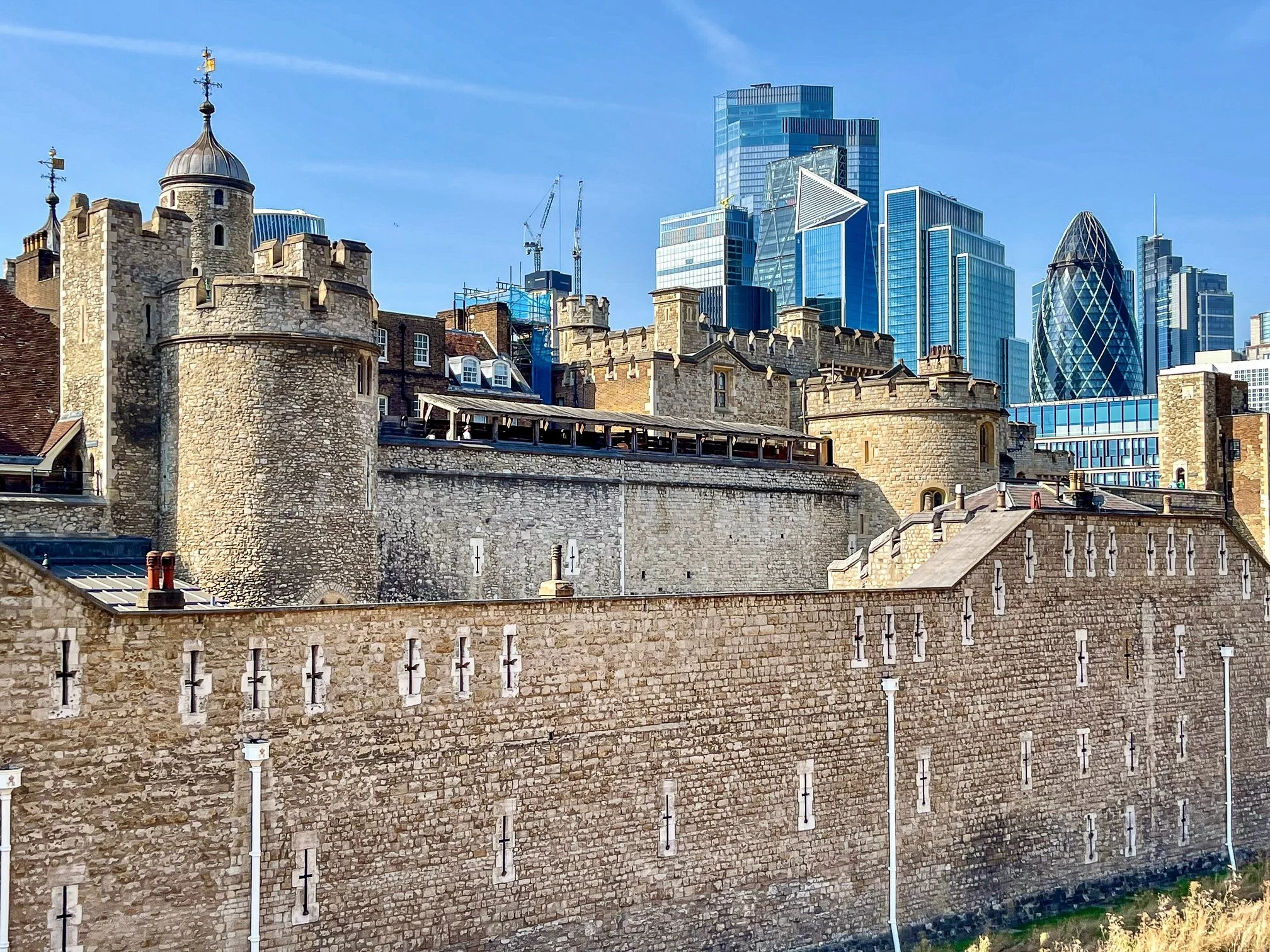  I took this photo of the Tower of London and the City of London skyline while crossing the Tower Bridge. William the Conqueror started to construct the Tower of London in 1066, with the inner White Tower likely beginning around 1078. Over the centur