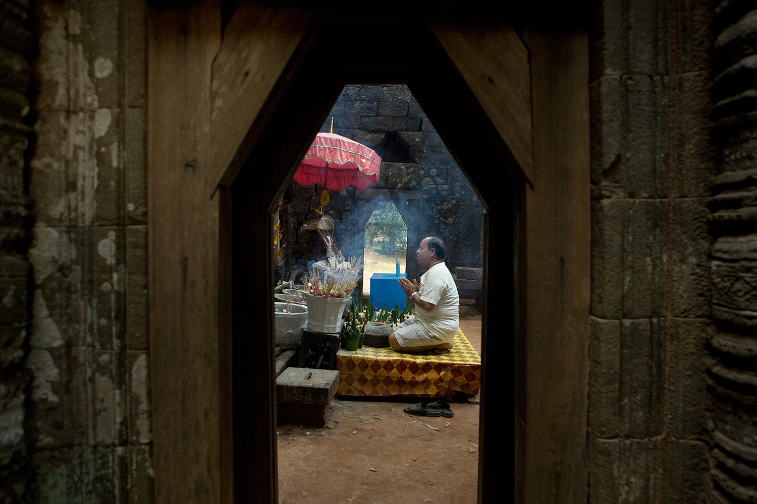  A lay Buddhist lights incense and leaves an offering at the ancient shrine Wat Phu Champasak in Laos. 