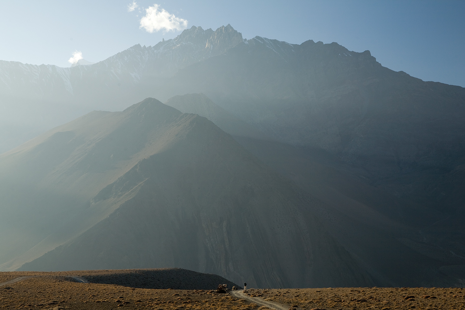  Just before the sun sets, and the wind howls through the barren canyon, a trekker stands above the town of Kagbeni. 
