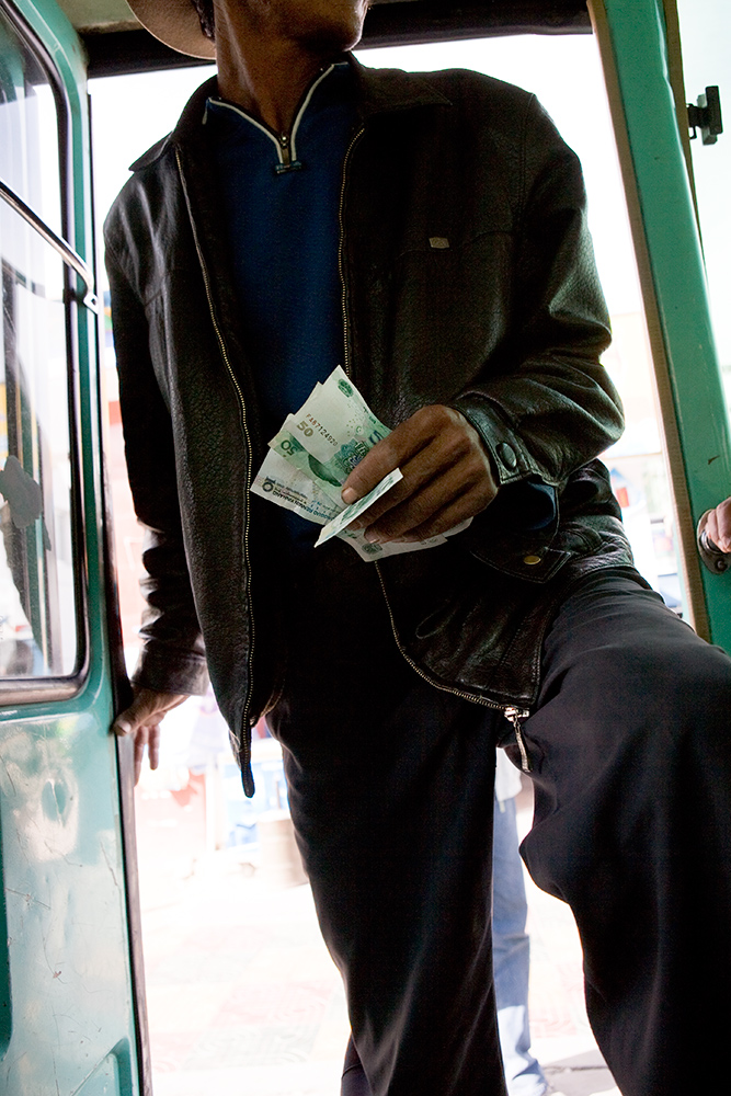  A Tibetan man boards a small bus traveling towards Lhasa from the countryside. 