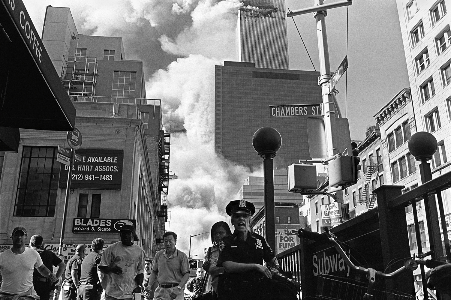  A police officer yells for people to run away as the south tower of the World Trade Center collapses on September 11, 2001. 