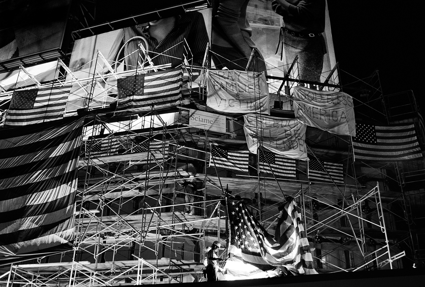  In Times Square construction workers hang American flags from scaffolding just before a rain on September 13, 2001. 