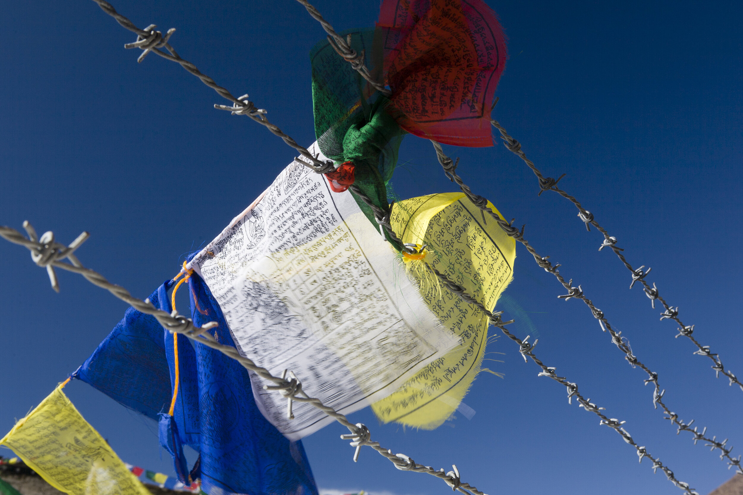  Barbed wire and Tibetan prayer flags protect the Muktinath-Chumig Gyatsa temple in a remote area on the Annapurna Circuit. 