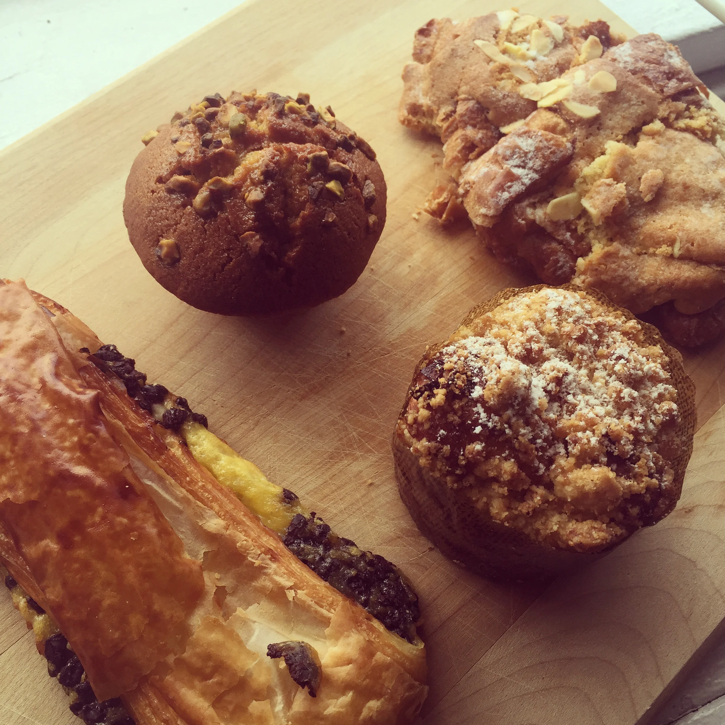 Clockwise from left: pain au chocolat, pistachio financier, almond croissant, apple brioche