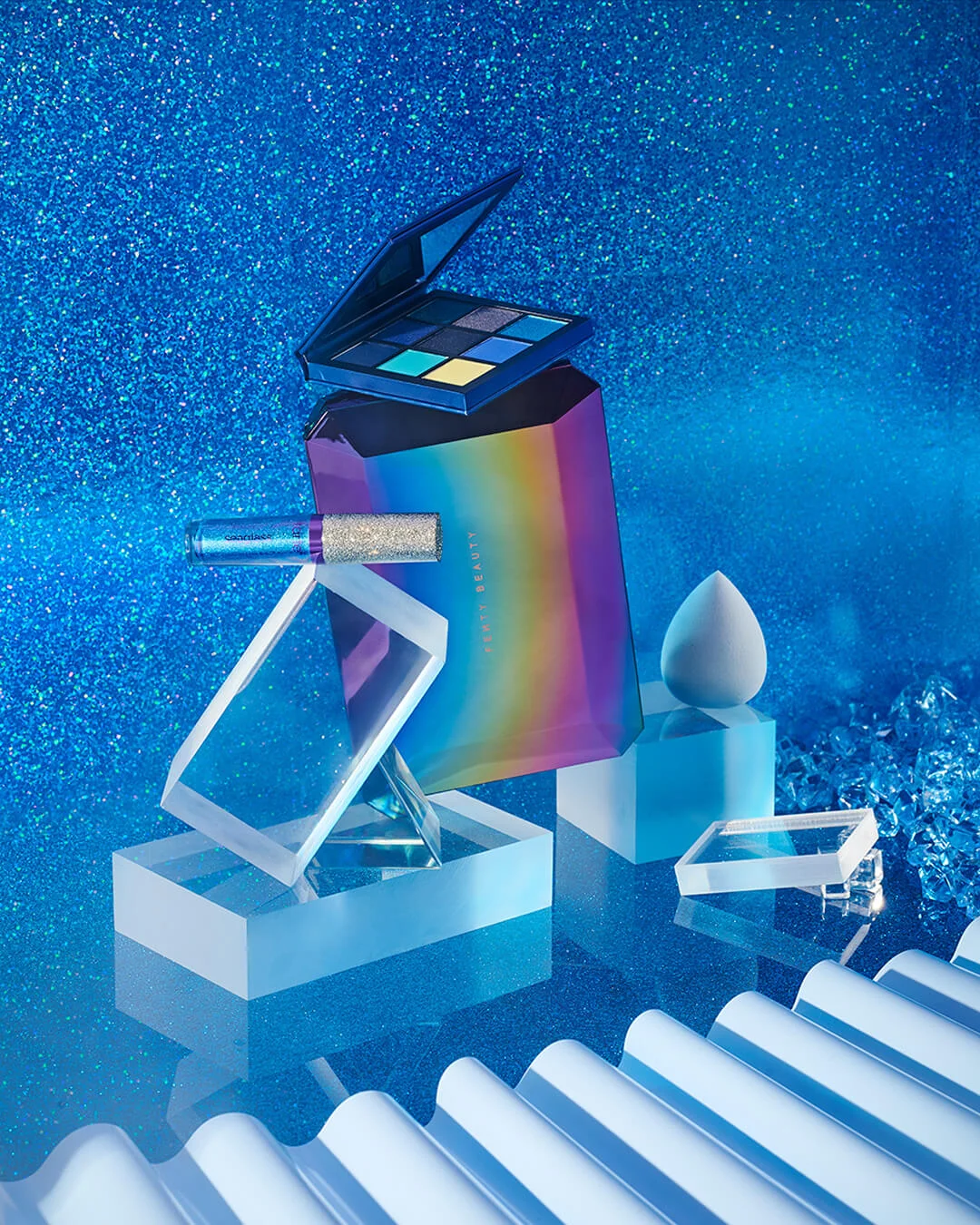 credits: photo - jenna gang, styling - astrid chastka description: conceptual still life image of fenty beauty and a beauty blender in a cold blue outer space world.