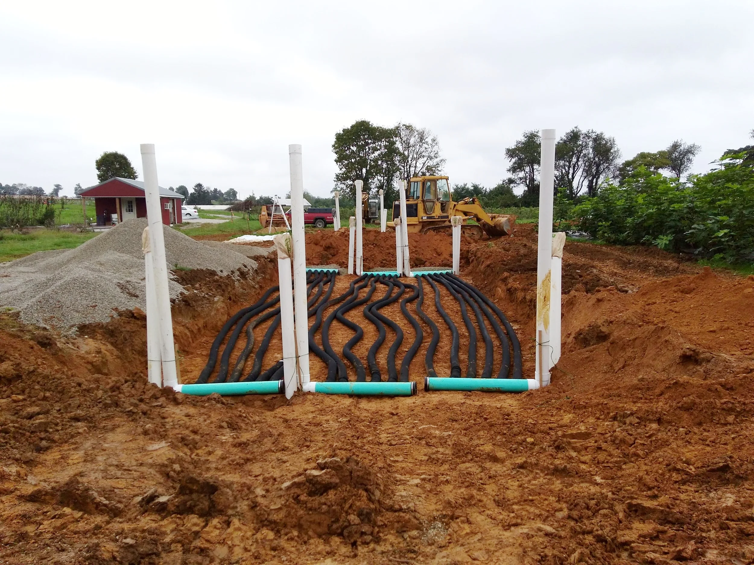 Hole backfilled to 3 feet with the second layer of tubing partially covered. Here you can see the lower risers partially buried. Risers were positioned to allow for tractor entry into the greenhouse.