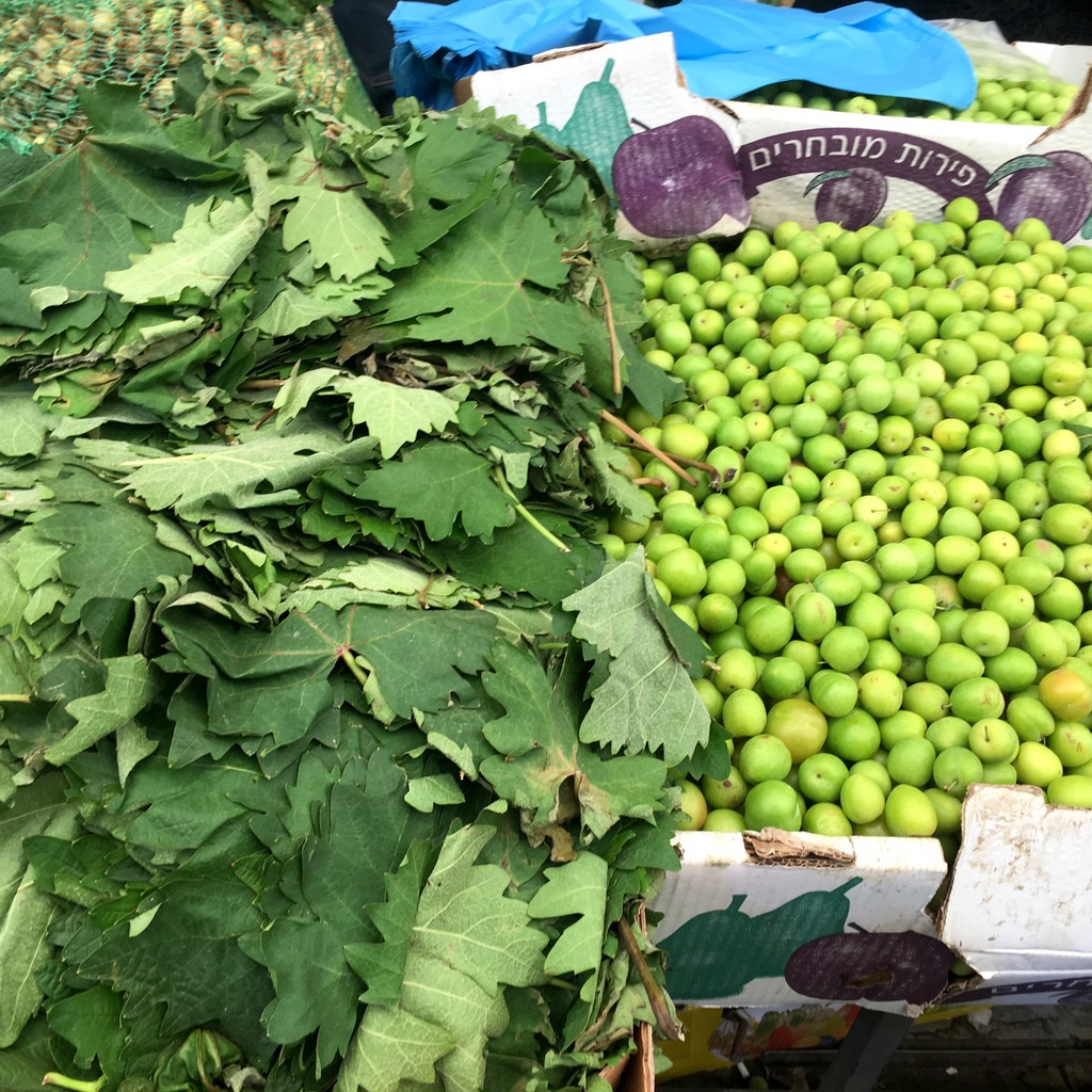 Vine leaves and sour spring plums - for cooking not eating - at Jerusalem's Mahane Yehuda Market. 