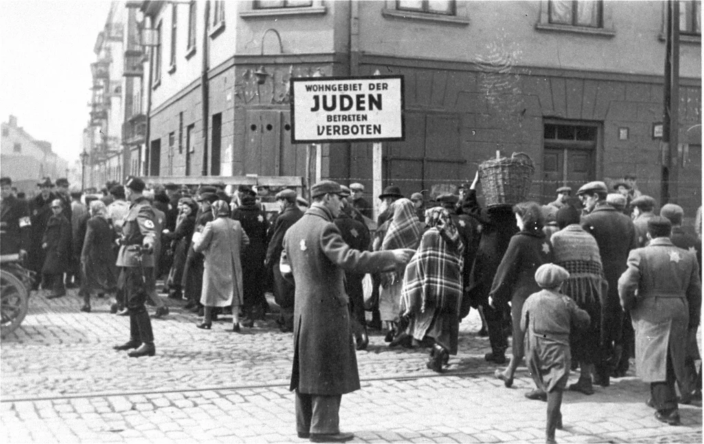 Jews moving into the Lodz Ghetto - known as Litzmannstadt to the Nazis. The sign says that entry to non-Jews is forbidden. (Photo: Bundesarchiv)