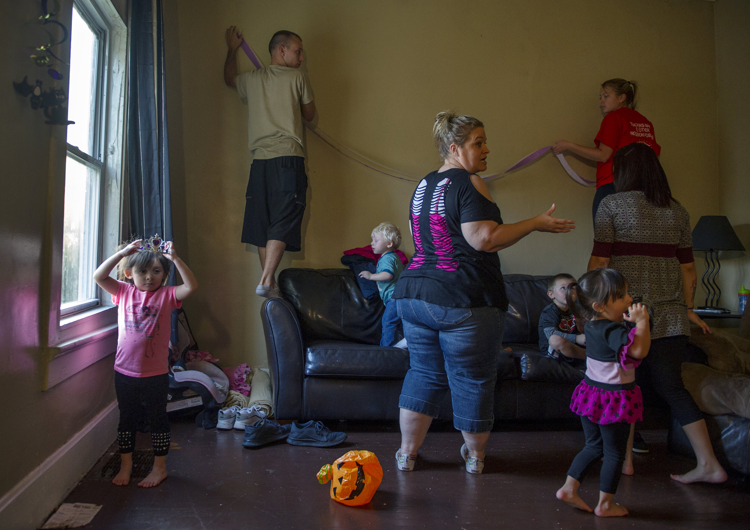  Ana Williams, 4, (left) puts on a tiara while members of her family decorate for her sister Priscilla's third birthday party at their home in Evansville, Ind. The girls' mom, Angelica Williams, 21, is pregnant with her third child, but plans to give