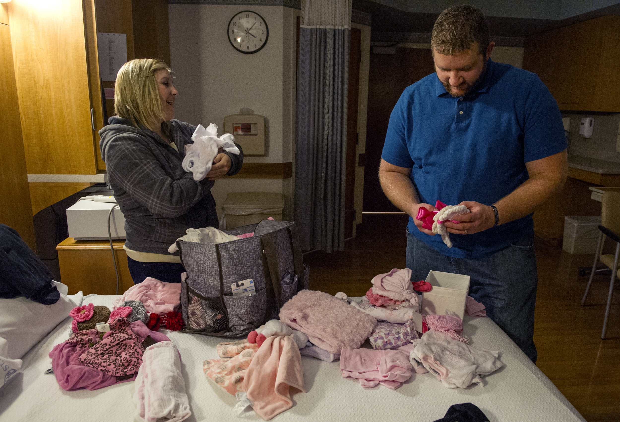  Erickia pretends to rock a baby while she unloads the clothes she brought to choose from for Gracelyn's first outfit while Michael decides on the first hat that his daughter will wear in their room at St. Mary's Medical Center in Evansville Monday D