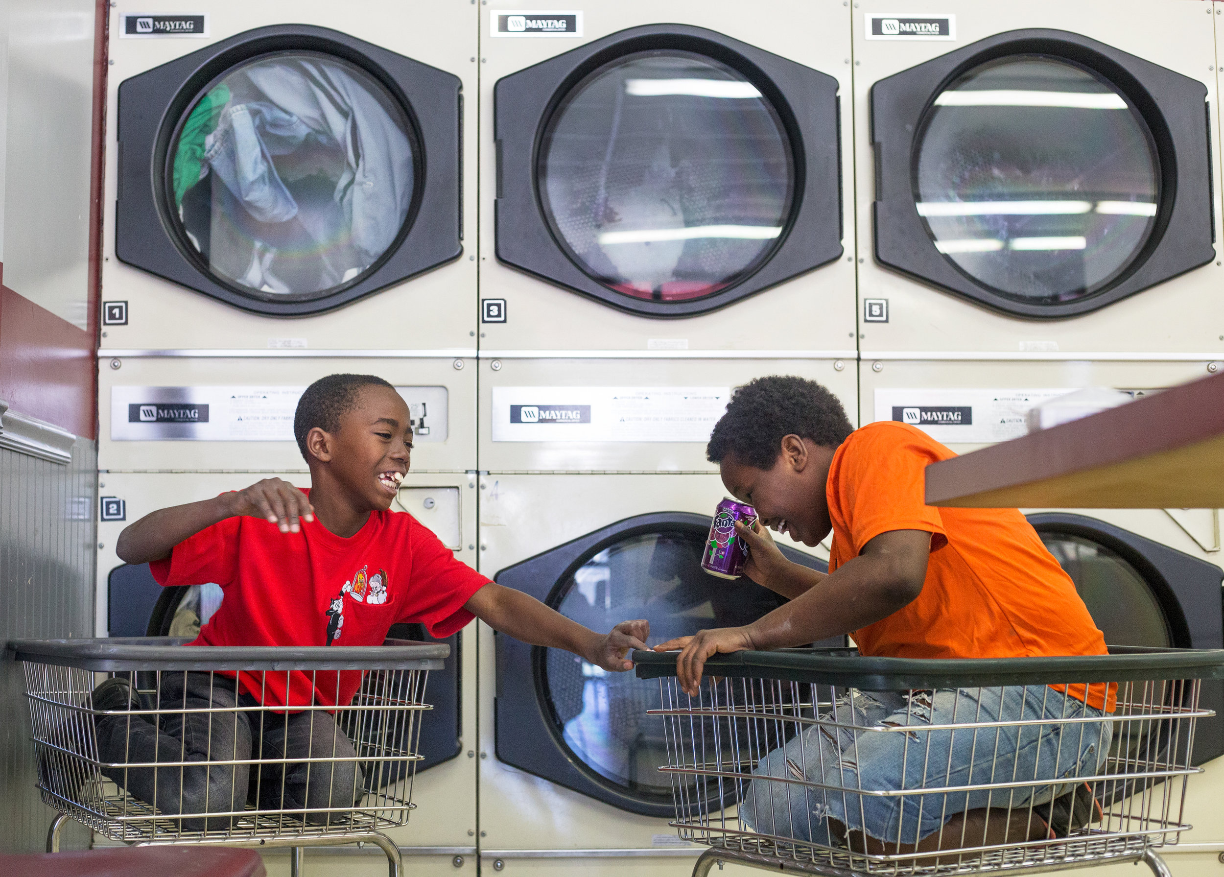  Mohammed Kamara, 11, left, and Joseph Uwiz, 12, play in the laundry carts at Super Wash House in North Knoxville, April 5, 2017.  