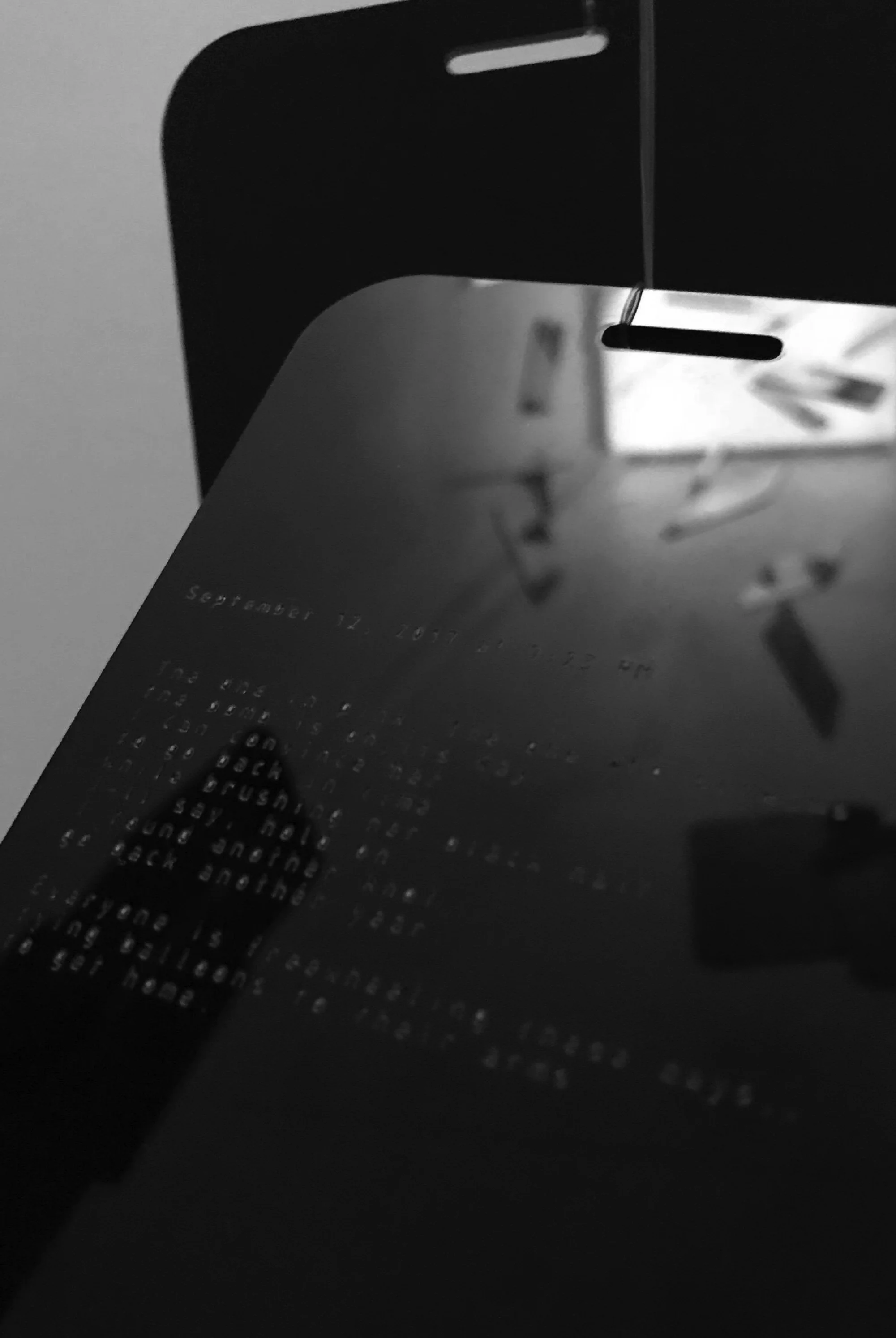  Caitlin Thissen/Jeannette Hinkle booth interior hanging poetry tags reminiscent of dark cell phone screens 