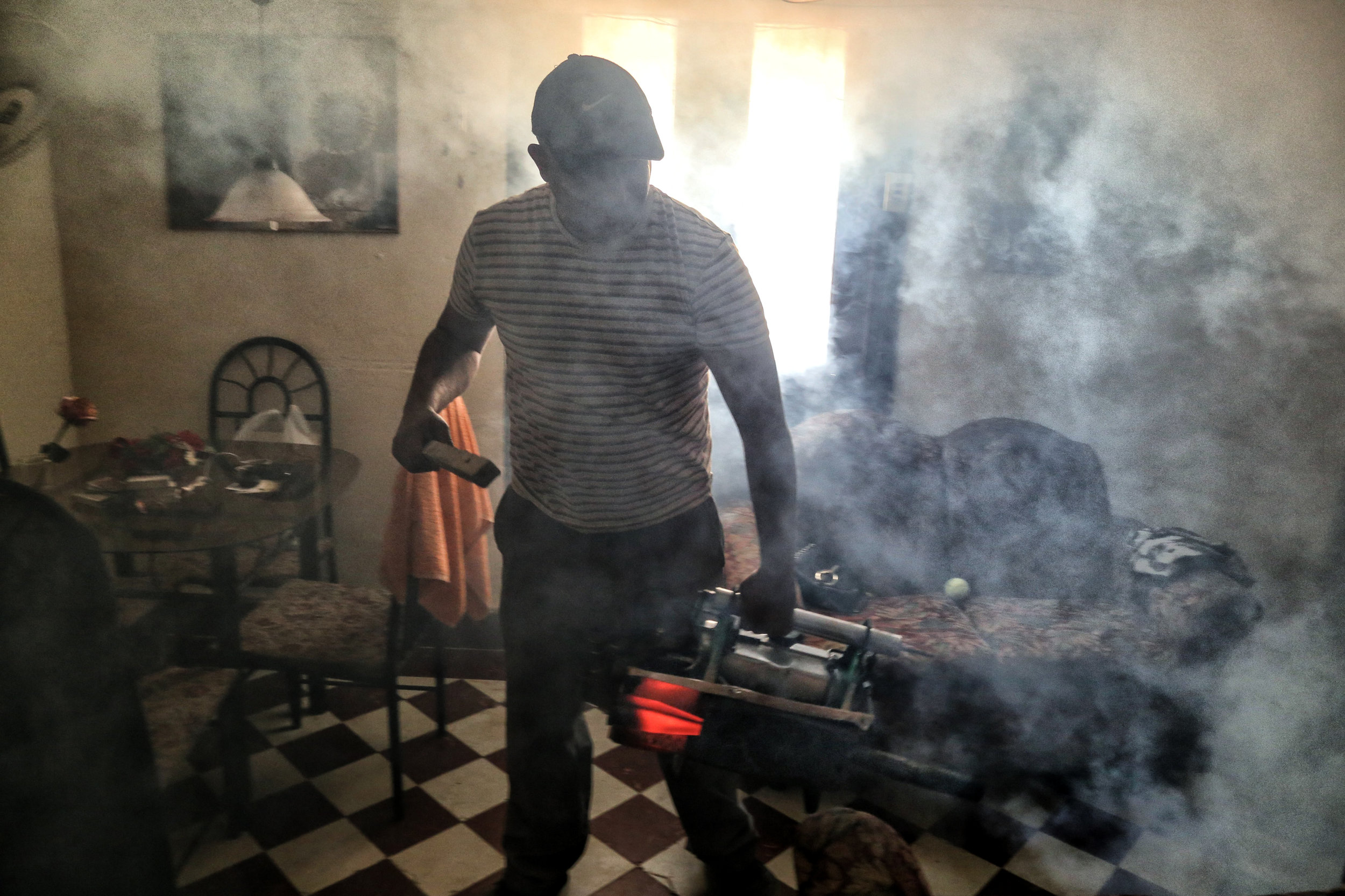 As the seventh case of Zika virus was detected in Cuba and the CDC issued a travel warning, the Cuban government increased its fumigation efforts throughout both residential and rural areas. Pictured above is an ordinary Cuban citizen, hired by the government, fumigating a home in Havana Vieja on March 30th, 2016.