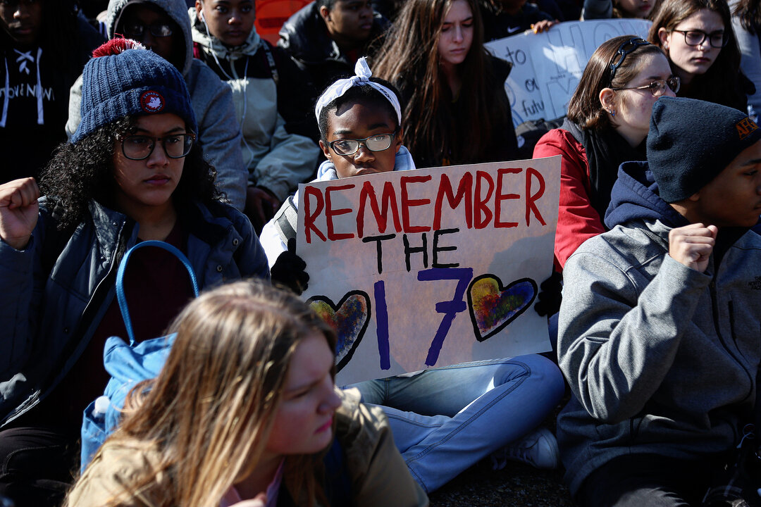 1) A student participating in the National Walkout holds a sign in front of the White House with the words &lsquo;Remember the 17&rsquo; in allusion to the students and teachers killed at Stoneman Douglas High School in Parkland, Florida one month ag