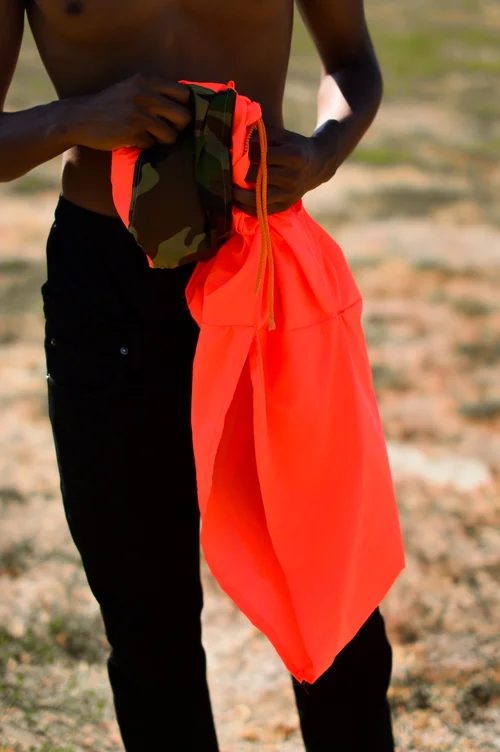  Waterproof Neon Orange hoodie. The hoodie transforms into a pouch with pockets by folding into it self.&nbsp;  The concept was to create an emergency hoodie. The color is very bright in any lighting which would allow someone lost to be found easily.