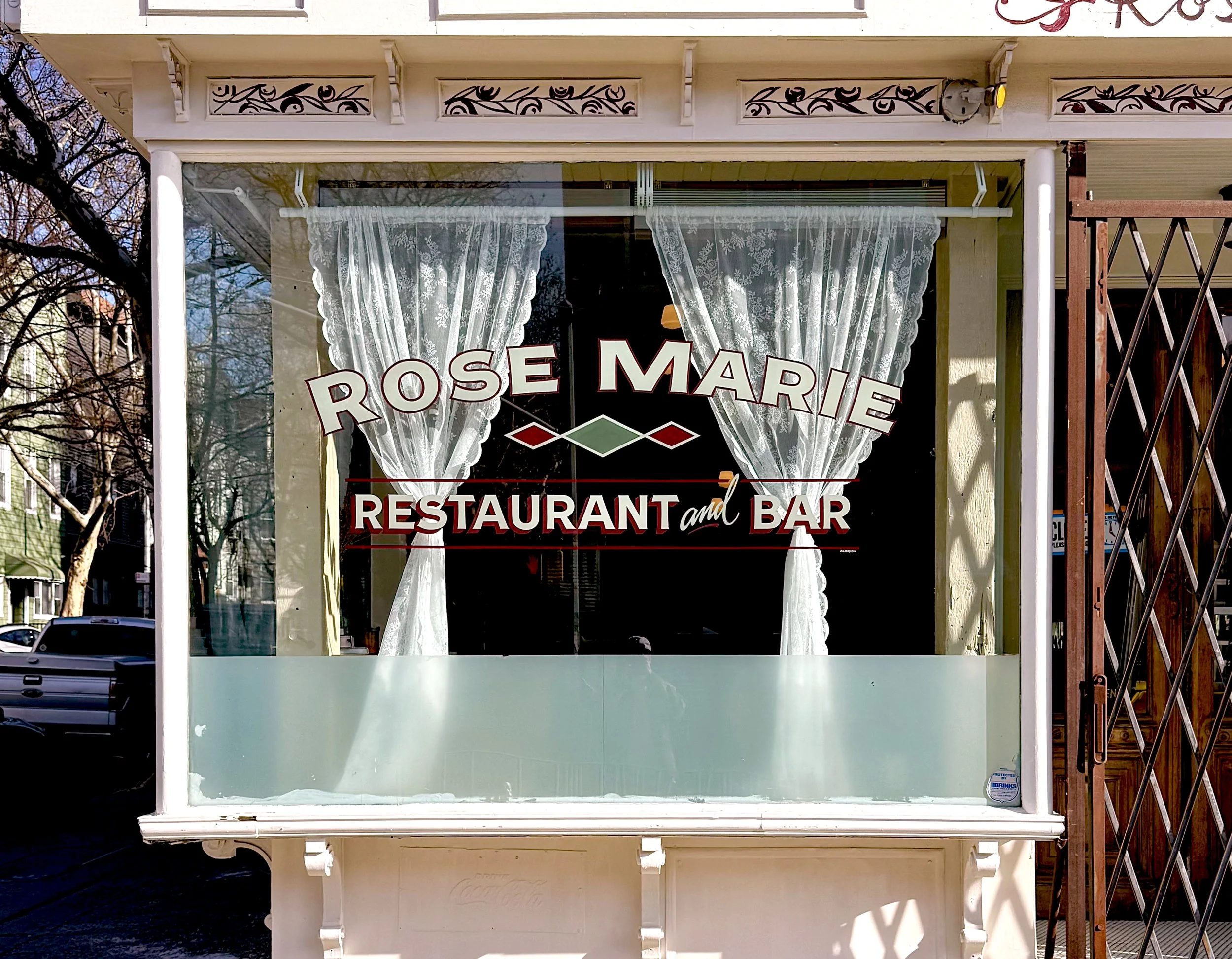 Hand painted sign on Brooklyn restaurant's storefront window.